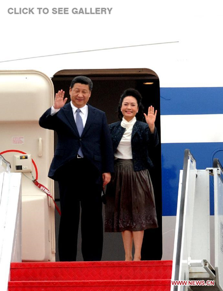 Chinese President (L) Xi Jinping and his wife Peng Liyuan wave as they arrive at the international airport in Macao, south China, Dec. 19, 2014. (Xinhua/Zhang Duo)