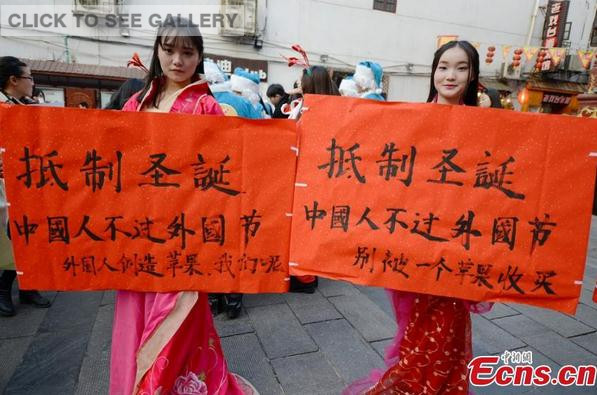 College students wearing traditional Chinese clothing join a campaign to boycott Christmas celebrations on a street in Changsha, Central China's Hunan province on December 24, 2014. [Photo: China News Service/ Yang Huafeng] 