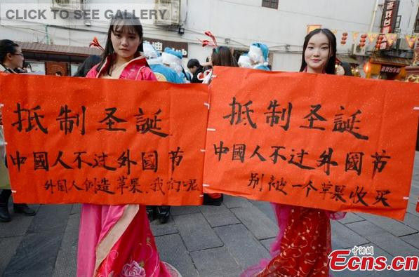College students wearing traditional Chinese clothing join a campaign to boycott Christmas celebrations on a street in Changsha, Central China's Hunan province on December 24, 2014. [Photo: China News Service/ Yang Huafeng] 