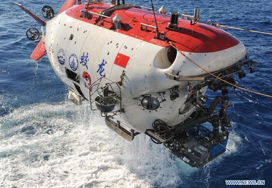 China's deep sea manned submersible Jiaolong is lifted out of water in the Indian Ocean, Jan. 2, 2015. Jiaolong carried out the first dive on a mission to study active hydrothermal vent in the southwestern Indian Ocean on Jan. 2. It was the first time for the submersible to take the second batch of pilot trainees in the diving, which was intended to enable the trainees to learn some skills of submersible operation in active hydrothermal vent and collect samples of hydrothermal fluid, sulfide, rocks, sediment and water. (Xinhua/Zhang Xudong)