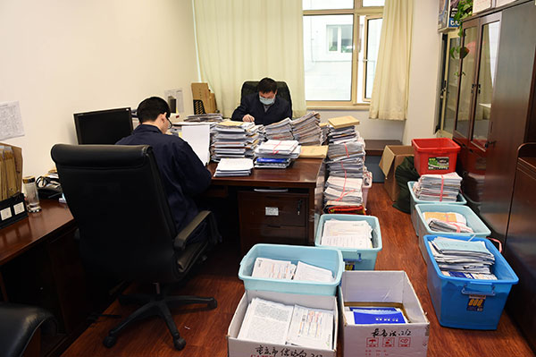 Two officials read the letters that have been sorted and opened. [Photo/ CCDI website]  