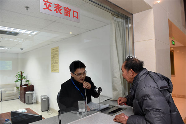 A petitioner hands in his registration form to an official. [Photo/ CCDI website]