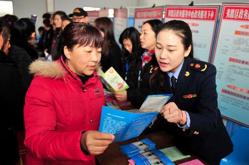 STREAMLINED FORMALITIES: Administrative staffs explain the one-stop convenience services to local farmers in Yiling District, Yichang, Hubei province on March 6, 2014 (CHINA NEWS SERVICE)