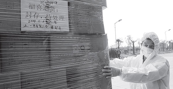 Workers of Shanghai Husi Food Co, entrenched in a food safety scandal that led to the arrest of six senior executives and a nationwide recall of its products, destroy the recalled 521.2 metric tons of foodstuff with biosafety disposal measures in Shanghai on Sunday. Yong Kai / for China Daily  