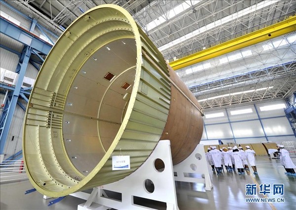 Photo taken on Dec 12, 2014 shows staff members check the fairing of the Long March-5 rocket. (Xinhua/ Yue Yue)