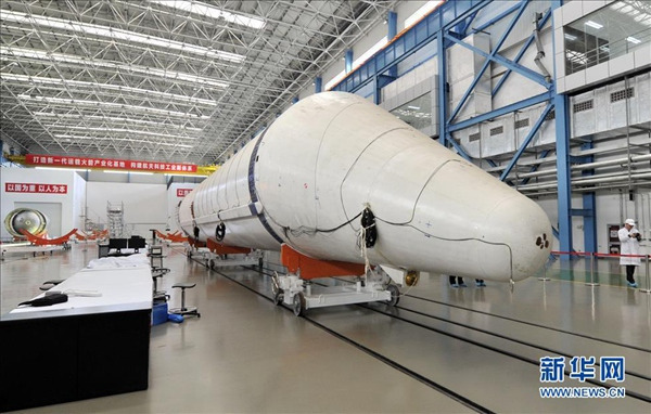 Photo taken on Dec 12, 2014 shows staff members examine the Long March-5 rocket in progress. (Xinhua/ Yue Yue)