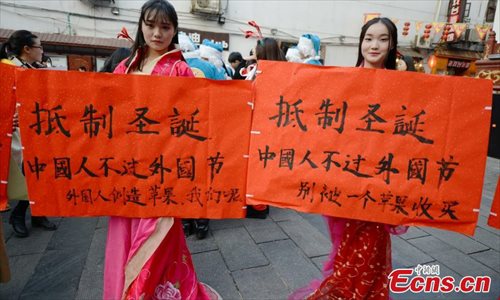 College students wearing traditional Chinese clothing join a campaign to boycott Christmas celebrations on a street in Changsha, Central Chinas Hunan province on December 24, 2014. With slogans saying Boycott Christmas-Chinese dont celebrate foreign festivals in hands, these students call on people to focus on Chinese traditional festivals and celebrate festivals in a rational way. (Source: China News Service/ Yang Huafeng)