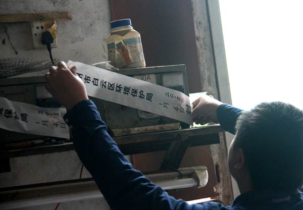 Equipment at a watchmaking plant is sealed by a member of the environmental supervision team of Guangzhou, Guangdong province, on Jan 4 after the company was found to be seriously polluting the surrounding environment. [Photo/China Daily]