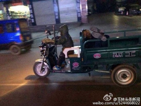 A boy rides a tricycle carrying his drunken father home in Yizhou city, South China's Guangxi Zhuang autonomous region, Jan 6, 2014. [Photo/weibo.com]