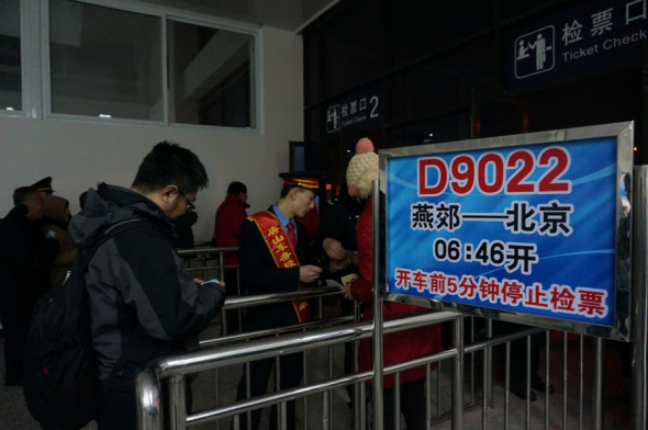 Railway employee checks the tickets of passengers of D9022, a bullet train between Yanjiao and Beijing, at Yanjiao Railway Station in Langfang city, Hebei province, Jan 12, 2015. Three bullet trains between Yanjiao, dubbed city of beds, and the capital went into operation on Monday, providing more options for the inter-city commuters. [Photo by Zhang Xiang/chinadaily.com.cn]