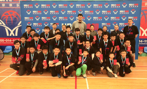 Yao Ming poses with students at the NBA Yao Basketball Club Shanghai launch ceremony in Shanghai Jan 11, 2015. Provided to chinadaily.com.cn  