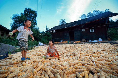 A HAPPY LIFE: Two children play in front of a local residential house of the Tujia ethnic group in Guzhang County, central China's Hunan province, a listed poverty-stricken area, on September 2, 2014. The county aims to develop tourism based on their unique minority ethnic culture (XINHUA)