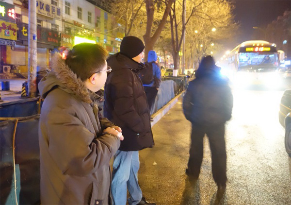 Zhao Wei (L) waits for 814 bus, Jan 12, 2015. [Photo by Song Wei/chinadaily.com.cn]  