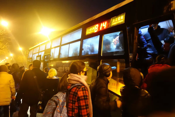 Passengers board a packed 814 bus in Yaojiao in the early morning, Jan 12, 2015. [Photo by Song Wei/chinadaily.com.cn]  