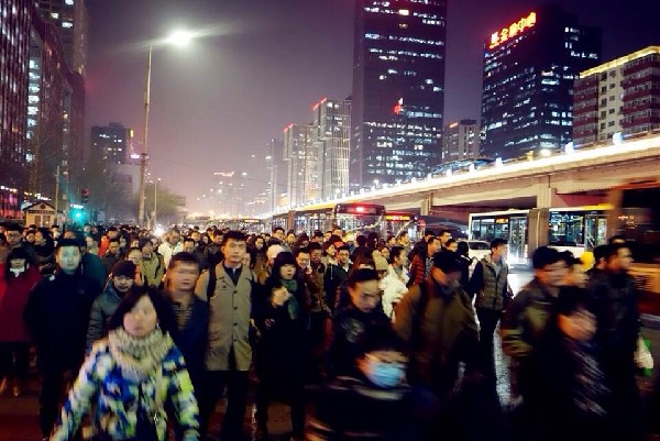 Commuters walk to the Yaojiao bound bus stations after work in Central Business District of Beijing, Jan 9, 2015. [Photo by Song Wei/chinadaily.com.cn]  