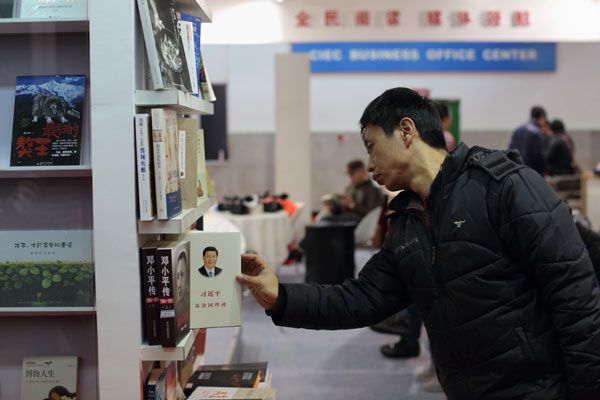 A reader looks at a new book on Chinese President Xi Jinping at the 2015 Beijing Book Fair. [Photo by Wang Jing/China Daily]  