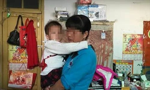  Zeng Guixiang holds her daughter Maomao who was infected with HIV through a blood transfusion.