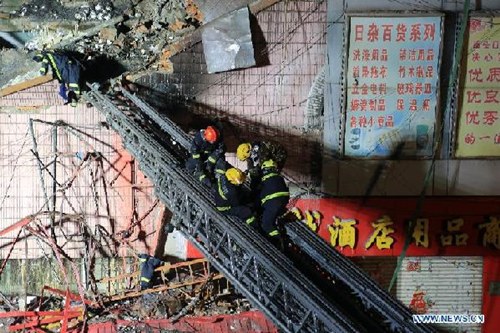 Rescuers save a buried firefighter on the scene of a warehouse fire at Beifangnanxun ceramics market in Harbin, capital of northeast China's Heilongjiang province, late on Jan 2, 2015. Five firefighters were dead and another 14 were injured, including a security, according to local authorities. [Photo/Xinhua]