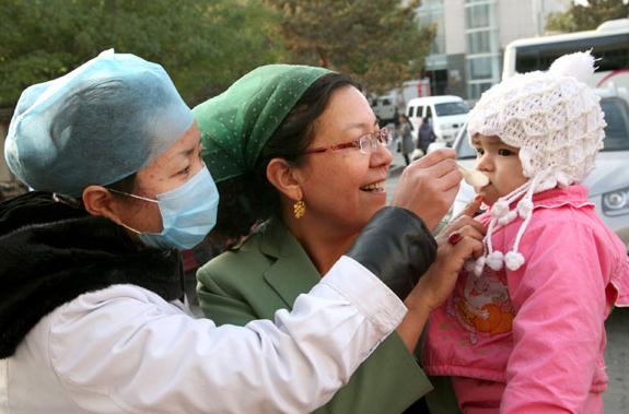 A medical worker gives a polio vaccine to a child in Hami prefecture in Northwest China's Xinjiang Uygur autonomous region. Cai Zengle / for China Daily  