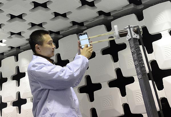 A Lenovo scientist tests the properties of the electric magnetism compatibility of its handsets in a production base in Wuhan, Hubei province. China has become a competitive place for investors in mobile technologies. [Photo/China Daily]