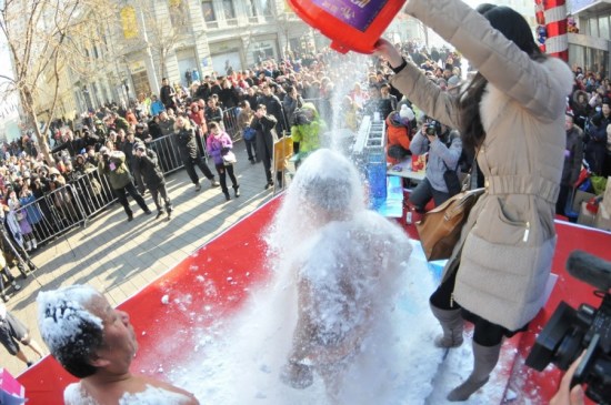 Guinness World Record holder Jin Songhao enduring the buckets of snow being thrown at him at the snow bucket challenge on Saturday, January 17, 2015, in northeast China's city of Harbin. [Photo/www.nen.com.cn]
