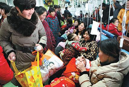Parents take their children to be fed by drips in a crowded room in a public hospital in Ganyu county, Jiangsu province. Many are now opting for private care for their families. Si Wei / for China Daily  