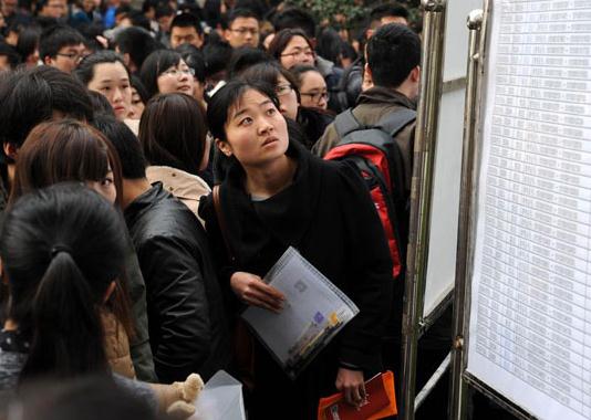A candidate examines the test schedule for the local civil servant examination in Jiangsu province, March 23, 2014. [Photo/Xinhua]  
