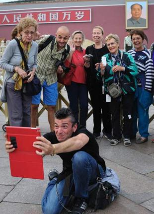 A group of tourists pose at Tian'anmen Square.  