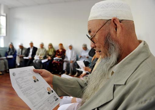 A Uygur man reviews papers related to his pilgrimage. [Photo/Xinhua]  