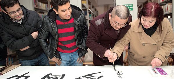 A calligraphy expert shows students how to use a traditional brush pen in Hefei, Anhui province, on Jan 13. Du Yu / for China Daily  