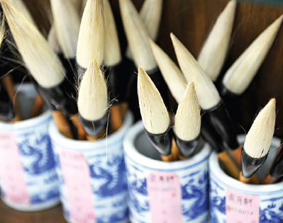 A selection of Huzhou brush pens, and Shi Wangli shows how they are made at the Wangyiping Brush Pen Store. Provided to China Daily  