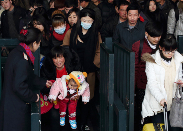 Passengers file through the ticket gates at Beijing Railway Station on Thursday. Millions of people have embarked on their trips home as Spring Festival approaches. WANG JING / CHINA DAILY