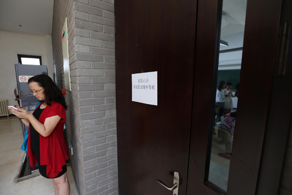 A parent waits outside a room at Peking University, where the University of Hong Kong interviewed mainland students in June for undergraduate admission.[LIN HUI/CHINA DAILY]