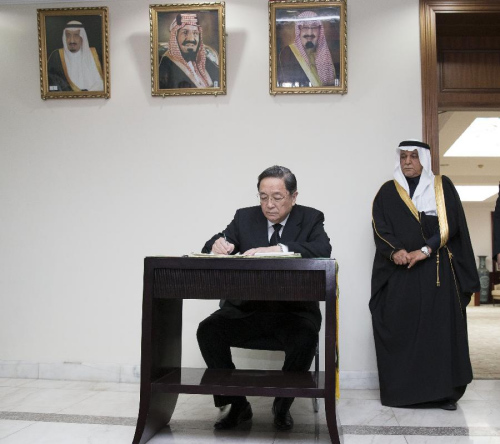 Yu Zhengsheng (L), chairman of the National Committee of the Chinese People's Political Consultative Conference (CPPCC), writes on a condolence book at the embassy of Saudi Arabia in Beijing, capital of China, Jan. 26, 2015. Yu Zhengsheng visited the embassy of Saudi Arabia in Beijing Monday morning to express condolences over the death of King Abdullah bin Abdulaziz. (Xinhua/Huang Jingwen)