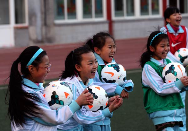 Students laugh during a soccer training course at Haidian National Primary School in Beijing on Tuesday. A European-style curriculum has been launched at the school. Meng Yongmin / Xinhua