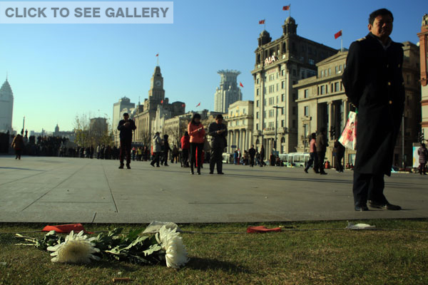 Flowers are placed on the ground to mourn the victims killed in a stampede in downtown Shanghai January 1, 2015. New Year's revelers crowded the Shanghai's Bund area around midnight on New Year's Eve when the tragedy occurred in Chenyi Square. At least 36 people were killed. [Photo by Ren Guoqiang/For chinadaily.com.cn]