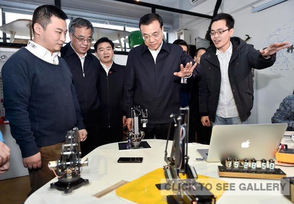 Premier Li Keqiang tried a remote control mechanical arm in Chaihuo Makerspace, an innovation platform in Shenzhen, Guangdong province, on Sunday. LIU ZHEN/CHINA NEWS SERVICE