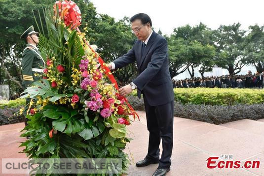 Premier Li Keqiang lays a flower basket adorned with ribbons at the foot of a statue dedicated to the memory of reform mastermind Deng Xiaoping in Shenzhen, Guangdong, on Monday morning, January 5, 2015.[Photo: China News Service/ Liu Zhen] 