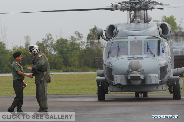 Indonesian Military Commander General Moeldoko (L) shakes hands with the pilot of USS Seahawk helicopter in Pangkalan Bun, Indonesia, Jan 6, 2015. The search operation for AirAsia Flight QZ8501 spreads slightly eastward on Tuesday as the weather and currents drag wreckage in that direction. (Xinhua/Agung Kuncahya B.) 