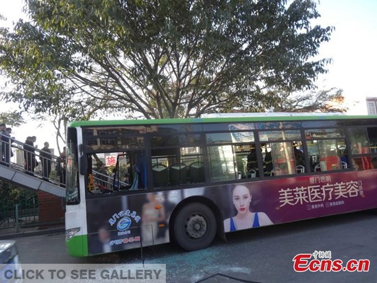 A bus stops after catching fire in its middle section on a street in Xiamen, East China's Fujian province, Jan 15, 2015. One passenger suffered burns while some others were injured following the emergency brake. Police also caught a suspect. [Photo/IC]