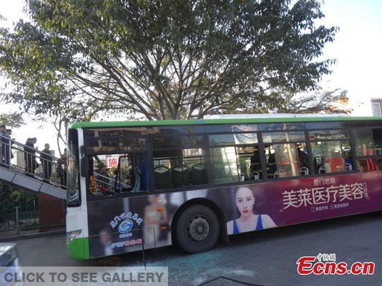 A bus stops after catching fire in its middle section on a street in Xiamen, East China's Fujian province, Jan 15, 2015. One passenger suffered burns while some others were injured following the emergency brake. Police also caught a suspect. [Photo/IC]