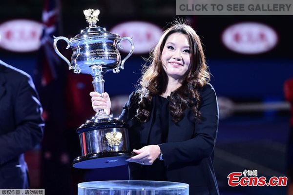 2014 Australian Open tennis champion Li Na of China poses with the trophy during her farewell ceremony at Rod Laver Arena on the first day of 2015 Australian Open tournament in Melbourne, Australia, Jan 19, 2015. Li Na shared her pregnancy news with the spectators during the event. [Photo: China News Service/Li Qing]