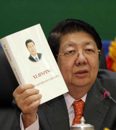 Cambodian Deputy Prime Minister and Cabinet Minister Sok An shows the book Xi Jinping: The Governance of China in Phnom Penh, Cambodia, Feb. 2, 2015. Hundreds of Cambodian students, academics and senior officials on Monday attended the launching ceremony of the book written by Chinese President Xi Jinping on governance. (Xinhua/Sovannara)