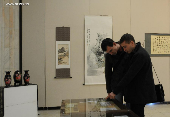 Two Romanians visit the Chinese culture exhibition held by Bucharest Confucius Institute in Bucharest, Romania, Feb. 3, 2015. (Xinhua/Lin Huifen) 