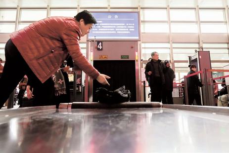 A man has his luggage scanned at the Shanghai Railway Station.  Kou Cong