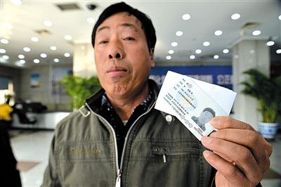 Wu Zhicheng shows his temporary identification card at a police department in Chaoyang district in Beijing on Feburary 4, 2015. [Photo/Beijing News]