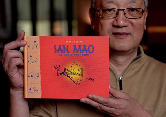 Zhang Weijun, the cartoonist Zhang Leping's son shows San Mao: Le Petit Vagabond. [Photo from Internet]  