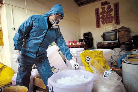A police officer checks the drugs seized during a raid in Guangdong Province. [photo: Shanghaidaily/Ti Gong]