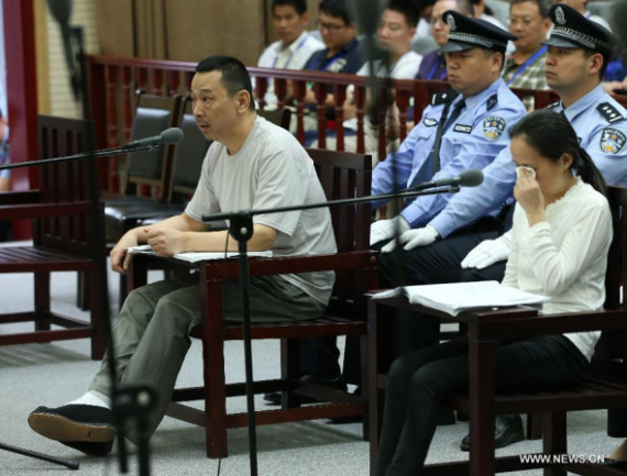Liu Han (L) sits in the courtroom at the intermediate people's court of Xianning City, central China's Hubei province, July 14, 2014. (Xinhua/Pang Xinglei)