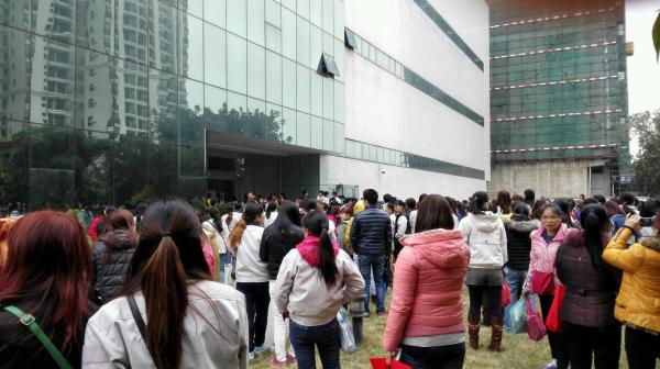 Workers wait outside the office building of Japanese watch maker Citizen in Guangzhou, Feb 5, 2015. [Photo/thepaper.cn]   